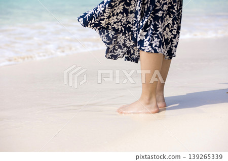 A woman's feet standing by the sea in a tropical paradise A woman's feet standing by the sea in a tropical paradise 139265339