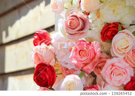 Beautiful arrangement of vibrant pink and red roses decorating a rustic wooden wall background Beautiful arrangement of vibrant pink and red roses decorating a rustic wooden wall background 139265452