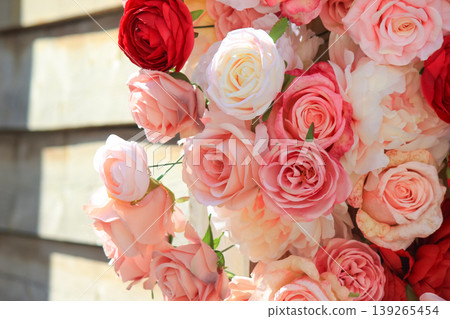 Beautiful arrangement of vibrant pink and red roses decorating a rustic wooden wall background Beautiful arrangement of vibrant pink and red roses decorating a rustic wooden wall background 139265454