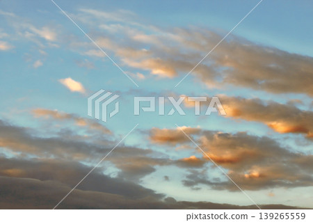Dramatic Golden Sunset Clouds on Dark Blue Sky. Breathtaking high-contrast sky at sunset. Golden light illuminates dark storm clouds against a deep blue dusk sky. Dramatic Golden Sunset Clouds on Dark Blue Sky. Breathtaking high-contrast sky at sunset. Golden light illuminates dark storm clouds against a deep blue dusk sky. 139265559