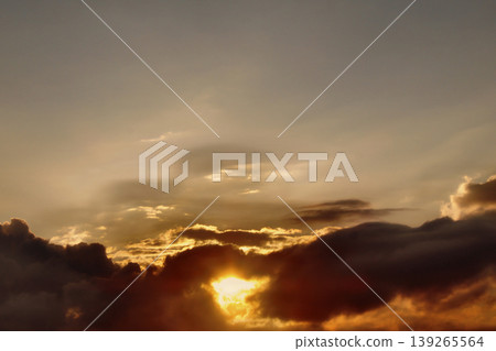 Dramatic Golden Sunset Clouds on Dark Blue Sky. Breathtaking high-contrast sky at sunset. Golden light illuminates dark storm clouds against a deep blue dusk sky. 139265564