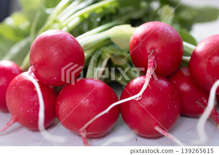 Fresh red radish with green leaves. Healthy vegetable as source of fiber and vitamin. Organic food ingredient for salad preparation Fresh red radish with green leaves. Healthy vegetable as source of fiber and vitamin. Organic food ingredient for salad preparation 139265615