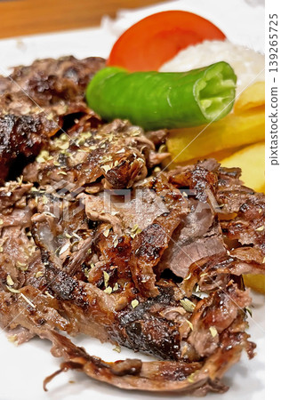 Turkish Beef Doner Kebab Plate with Rice and Fries. Traditional Turkish meat doner served with buttered rice, grilled pepper, tomato, and french fries. A delicious Mediterranean lunch. Turkish Beef Doner Kebab Plate with Rice and Fries. Traditional Turkish meat doner served with buttered rice, grilled pepper, tomato, and french fries. A delicious Mediterranean lunch. 139265725