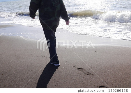 A child walking along the waterline (at their feet) A child walking along the waterline (at their feet) 139266158