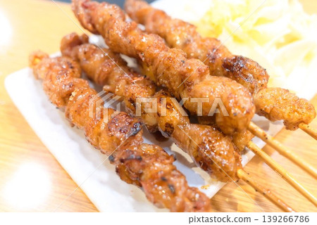 香氣撲鼻的烤雞肉串，盛在白色盤子裡。 139266786