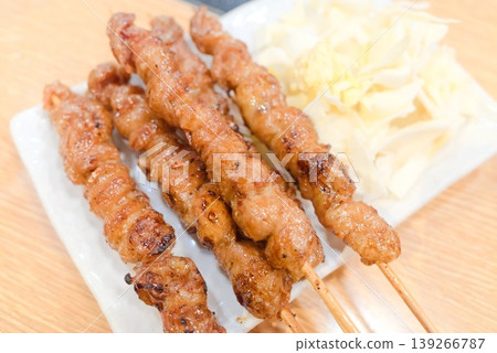 香氣撲鼻的烤雞肉串，盛在白色盤子裡。 139266787