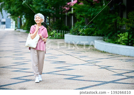 Full body of a senior woman strolling in a square 139266810