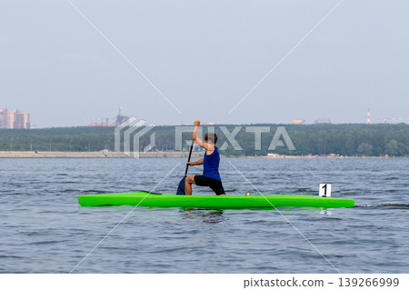 Athlete canoeist paddling on open water Athlete canoeist paddling on open water 139266999