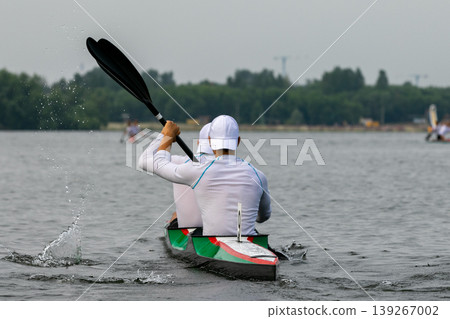 Rear view athletes kayakers paddling during double kayak Rear view athletes kayakers paddling during double kayak 139267002