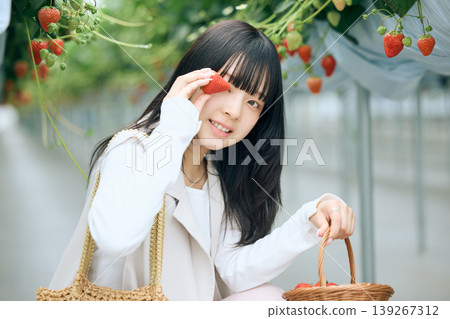 年輕女子享受採摘草莓的樂趣；日本女子在溫室草莓農場手捧草莓，笑容燦爛。 139267312
