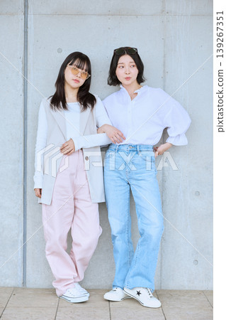 兩位年輕女子穿著白色上衣,享受春日郊遊——好友間的休閒時尚合照。 兩位年輕女子穿著白色上衣,享受春日郊遊——好友間的休閒時尚合照。 139267351