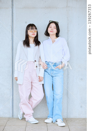 兩位年輕女子享受著春日郊遊；朋友並肩而立，都穿著白色和粉紅色的衣服。 139267353