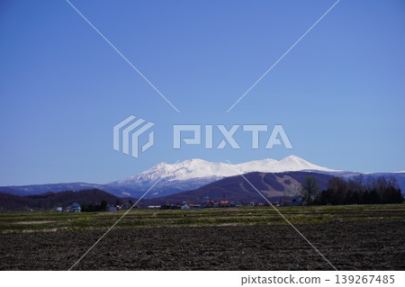 Snow-capped Daisetsuzan Mountains and spring farmlands: A spring scene in Hokkaido Snow-capped Daisetsuzan Mountains and spring farmlands: A spring scene in Hokkaido 139267485