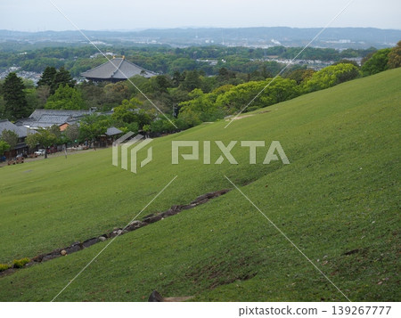 從若草山上可以欣賞到壯麗的景色。鬱鬱蔥蔥的山坡和奈良盆地的全景盡收眼底。 從若草山上可以欣賞到壯麗的景色。鬱鬱蔥蔥的山坡和奈良盆地的全景盡收眼底。 139267777