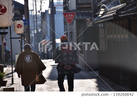 Inuyama City, Aichi Prefecture, Japan: A man wearing a happi coat walks down the street during the Inuyama Spring Festival, with lanterns displayed along the road. Inuyama City, Aichi Prefecture, Japan: A man wearing a happi coat walks down the street during the Inuyama Spring Festival, with lanterns displayed along the road. 139268642