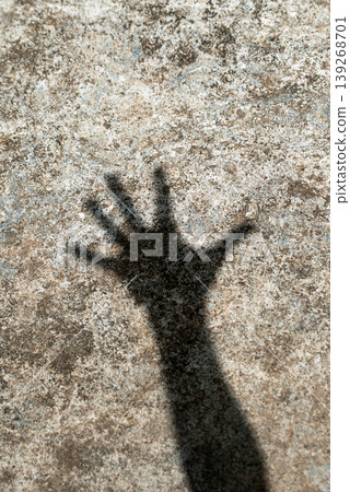Silhouette shadow of a reaching hand on a weathered plaster surface Silhouette shadow of a reaching hand on a weathered plaster surface 139268701