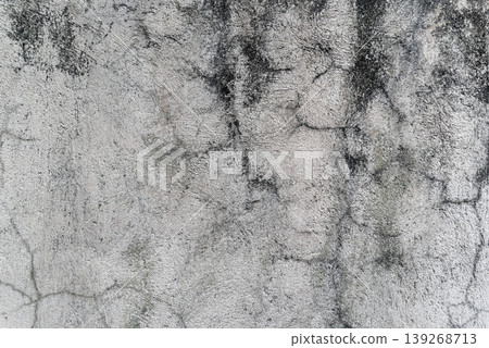 Close up of a gray weathered concrete wall texture with rough surface and cracks Close up of a gray weathered concrete wall texture with rough surface and cracks 139268713