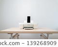 Minimal white printer with a smartphone docked on a light wooden desk, perfect for modern home office, wireless printing, technology convenience and clean workspace concept photography. 139268909