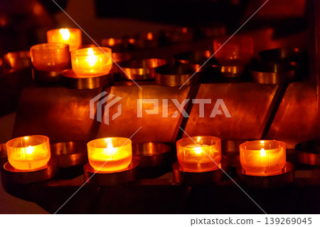 Many burning candles in a church 139269045
