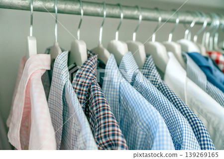 Close-up of shirts on hangers showing fabric textures and patterns. Fashion and wardrobe organization concept. Close-up of shirts on hangers showing fabric textures and patterns. Fashion and wardrobe organization concept. 139269165