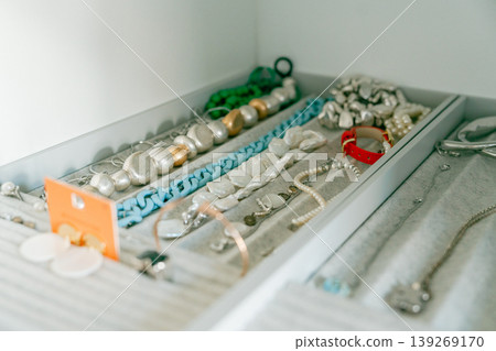 Jewelry neatly arranged in drawer organizer. Accessories storage and organization concept with clean minimal style. Rings, necklaces, and accessories placed in tray. Home organization and personal Jewelry neatly arranged in drawer organizer. Accessories storage and organization concept with clean minimal style. Rings, necklaces, and accessories placed in tray. Home organization and personal 139269170