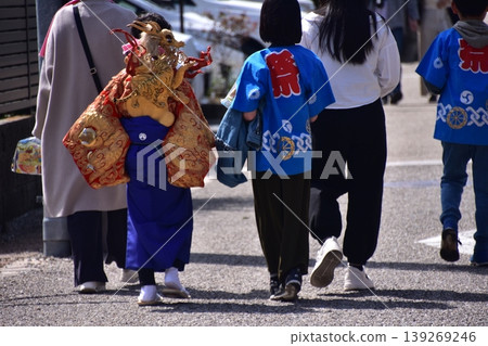 A family participating in the Inuyama Spring Festival in Inuyama City, Aichi Prefecture, Japan; a boy wearing a traditional gold undergarment. 139269246