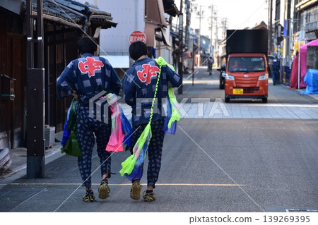 Inuyama City, Aichi Prefecture, Japan - A man wearing a traditional happi coat and a colorful obi (belt) is seen from behind as he takes part in the spring Inuyama Festival. 139269395