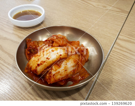 Traditional Korean Spicy Kimchi Served in Brass Bowl on Wood Table 139269620