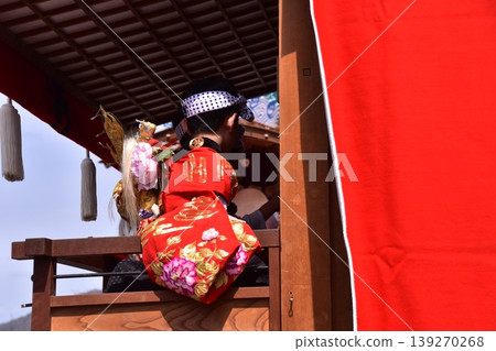 A boy participating in the Inuyama Spring Festival in Inuyama City, Aichi Prefecture, Japan, is seen riding on a festival float, wearing a gold undergarment and beating a small drum. A boy participating in the Inuyama Spring Festival in Inuyama City, Aichi Prefecture, Japan, is seen riding on a festival float, wearing a gold undergarment and beating a small drum. 139270268