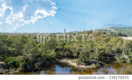 The ancient Roman lighthouse of Patara archaeological site rising above dense green forest in Lycia, Antalya, Turkey The ancient Roman lighthouse of Patara archaeological site rising above dense green forest in Lycia, Antalya, Turkey 139270835