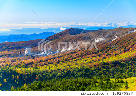 草津白根山的壯麗景色：山谷中升騰的火山煙霧、秋天的樹葉和雲海交織成一幅生氣勃勃的全景圖。 139270857
