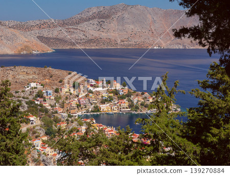 Symi harbor hillside with colorful houses and church by blue sea in Greece 139270884