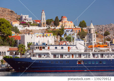 Cruise ship in Symi harbor with waterfront buildings on sunny clear summer day Cruise ship in Symi harbor with waterfront buildings on sunny clear summer day 139270912
