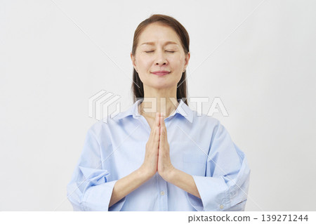 Elderly woman praying on white background Elderly woman praying on white background 139271244