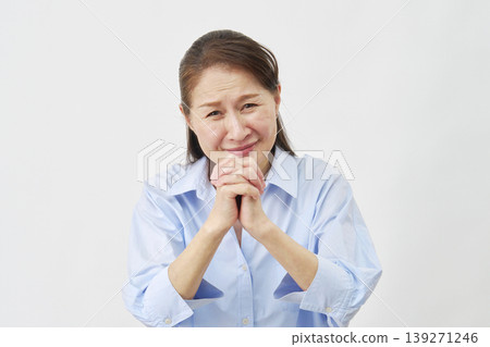 Elderly woman pleading on white background, looking at camera 139271246