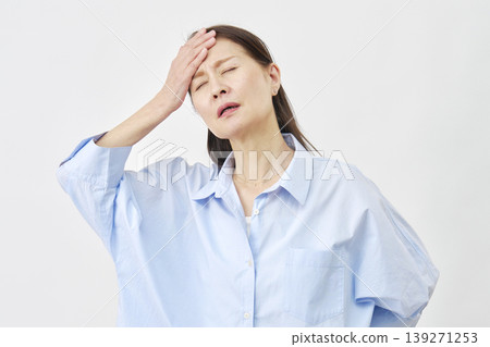 一位女子用手摀著額頭，背景為白色。 139271253