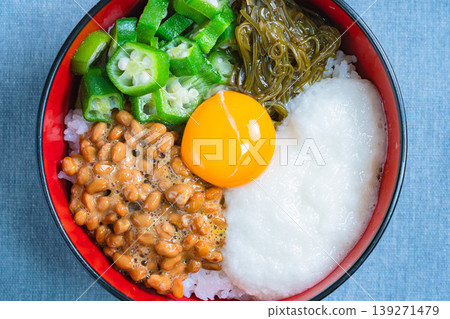 糯米飯碗:米飯上放有納豆、秋葵、磨碎的山藥、海苔和蛋黃。 糯米飯碗:米飯上放有納豆、秋葵、磨碎的山藥、海苔和蛋黃。 139271479