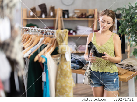 Young woman choosing shoes in store Young woman choosing shoes in store 139271731