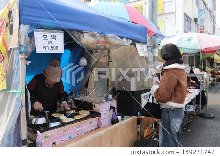 一名女子在韓國市場購買蓬鬆餅 一名女子在韓國市場購買蓬鬆餅 139271742