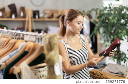 Young woman choosing high heel shoes in store Young woman choosing high heel shoes in store 139271776