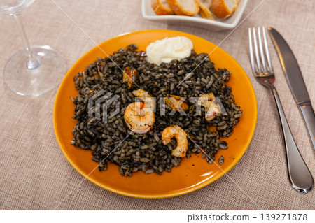 Paella is variant of dish made from black rice and seafood Paella is variant of dish made from black rice and seafood 139271878