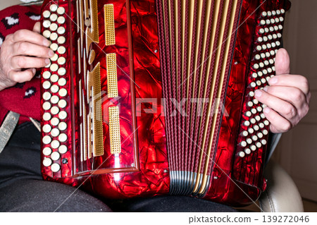 Person playing the accordion, a vintage musical instrument Person playing the accordion, a vintage musical instrument 139272046