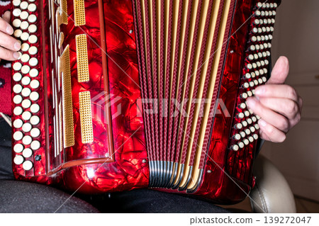Person playing the accordion, a vintage musical instrument 139272047