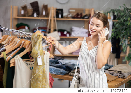 Woman making a phone call in a store Woman making a phone call in a store 139272121