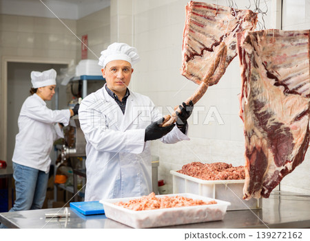 Butcher recommending raw sausages made of fresh minced meat 139272162