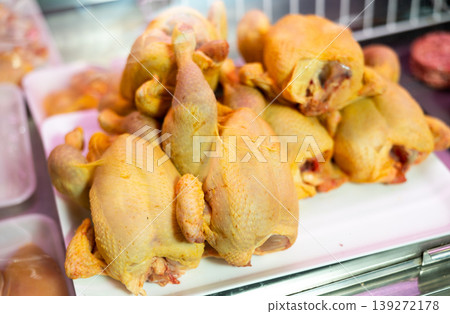 Refrigerated display case contains whole chilled chicken carcasses Refrigerated display case contains whole chilled chicken carcasses 139272178