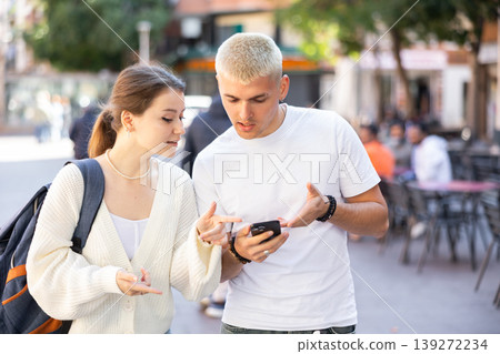 Couple walking around the city and looking at a map on mobile Couple walking around the city and looking at a map on mobile 139272234