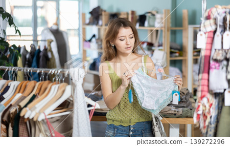 Young woman chooses panties in clothing store Young woman chooses panties in clothing store 139272296
