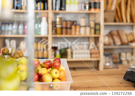 Ripe apples and pears on a grocery store counter. Bottles of alcohol in background 139272298