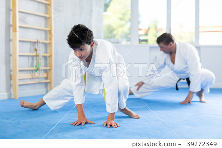 Man and boy teenager doing stretching in studio Man and boy teenager doing stretching in studio 139272349